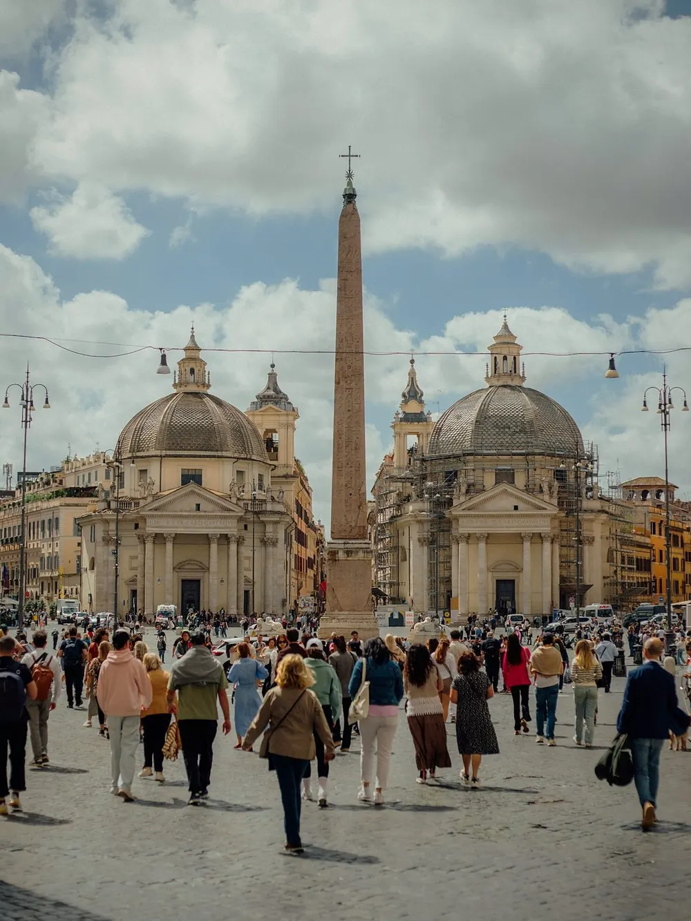 Piazza del Popolo in Rome with dozens of tourists walking across the square